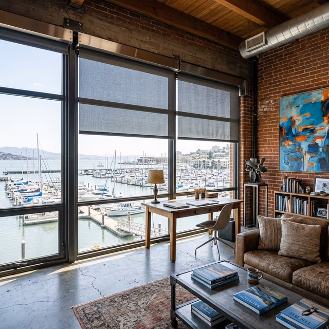 La Grange Window Coverings marine-grade Lutron motorized solar shades with salt-air resistant hardware filtering Richardson Bay light in a Marinship waterfront studio, Sausalito CA 94965