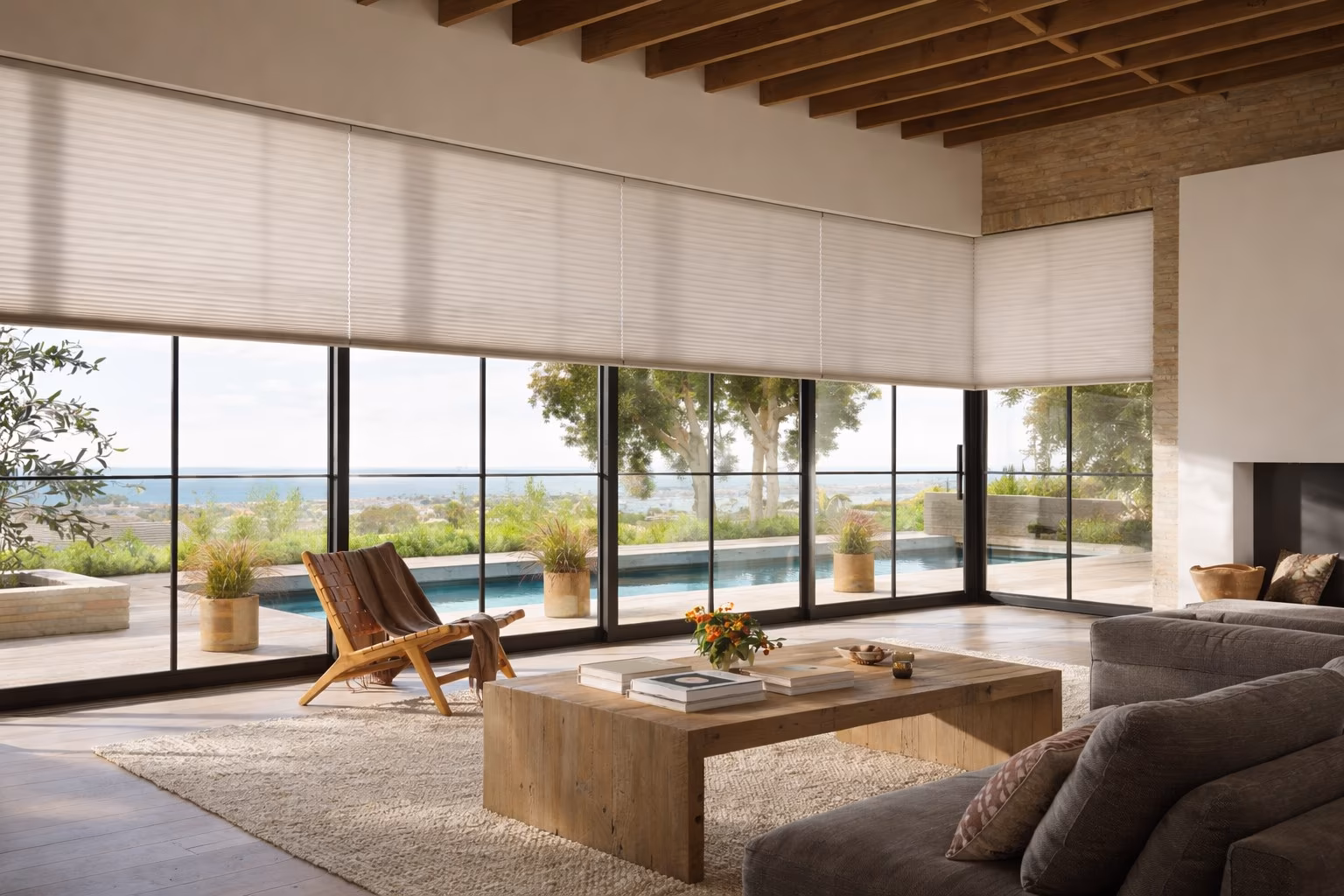 Hunter Douglas Duette Honeycomb Shades on floor-to-ceiling windows in a modern open-plan living room with pool view and mid-century furniture, installed by La Grange Window Coverings