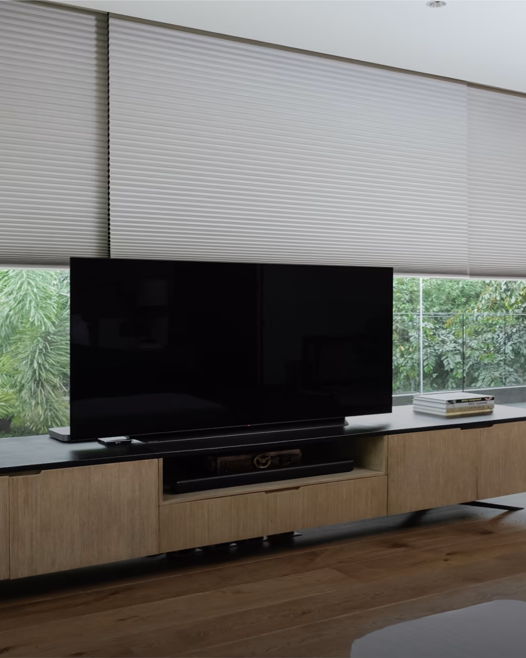 Hunter Douglas honeycomb cellular shades for thermal insulation behind living room TV console in Windsor home